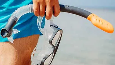 Male holding a snorkel at the beach