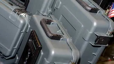 Close-up of stacked gray hard-shell cases with black handles.