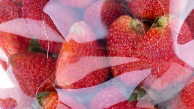 Fresh strawberries packaged inside clear plastic food packaging.