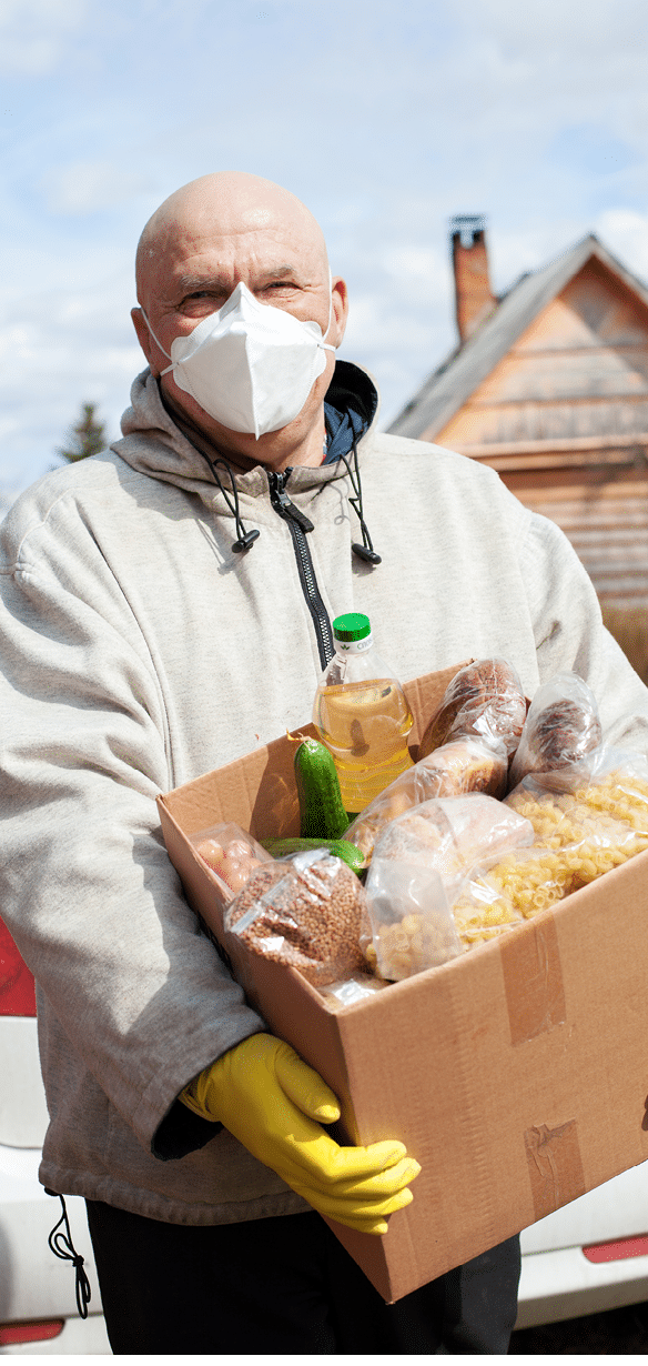 elderly male volunteer delivers food to   village